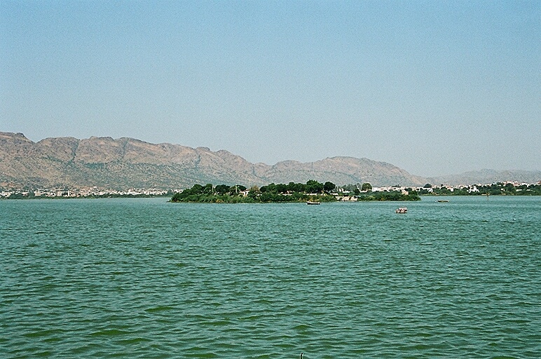 Wide view across the water of Ana Sagar Lake towards the Aravalli hills and the city of Ajmer